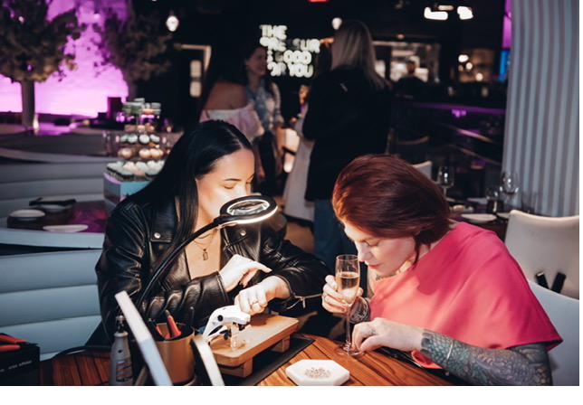Friends getting permanent jewelry at a private party